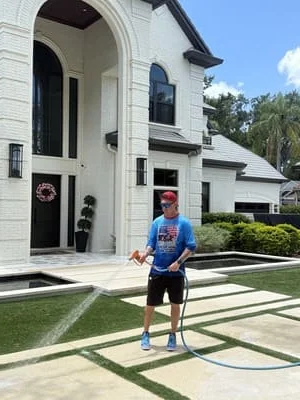 Professional pressure washing of a residential driveway and home exterior